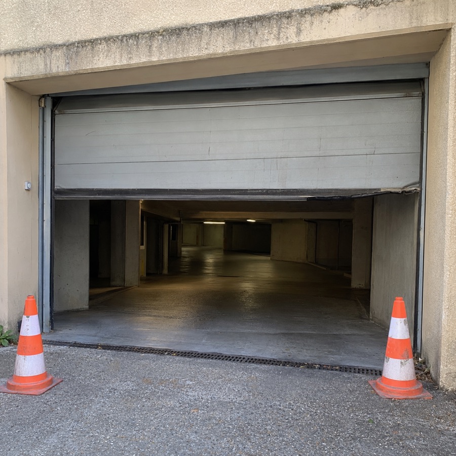 Photo envoyée dans le groupe : la porte du garage bloquée, deux cônes devant